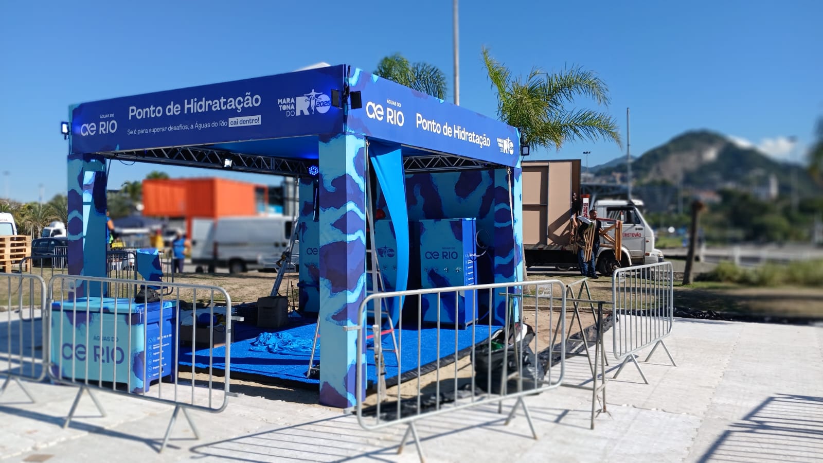 Stand Eventos Esportivos Stand Aguas do Rio na Maratona do Rio 2025 - ponto de hidratacao com estrutura azul e branding completo